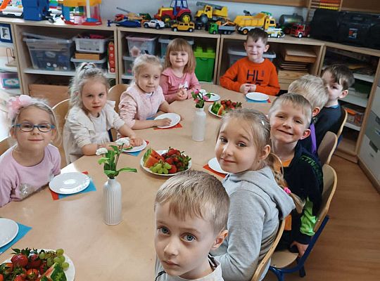 Dzieci przy stole z poczęstunkiem