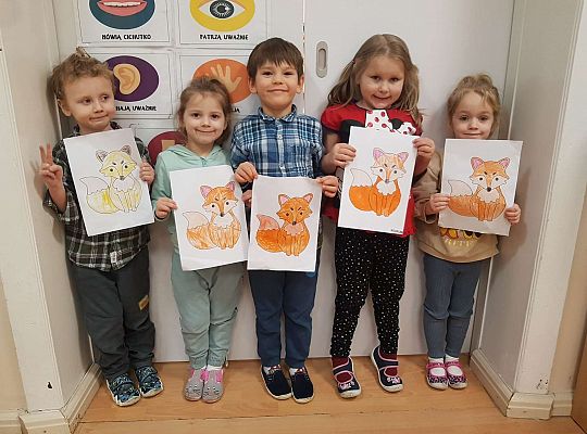 Dzieci stoją z obrazkami