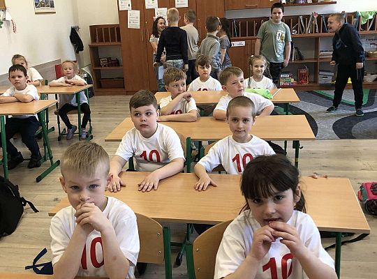 Dzieci siedzą w ławkach