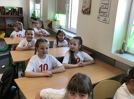 Dzieci siedzą w ławkach