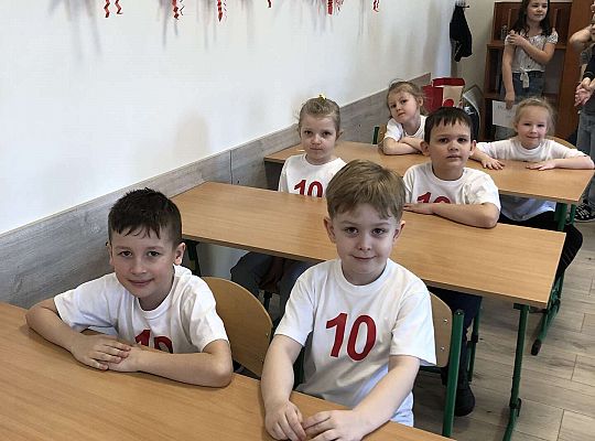 Dzieci siedzą w ławkach