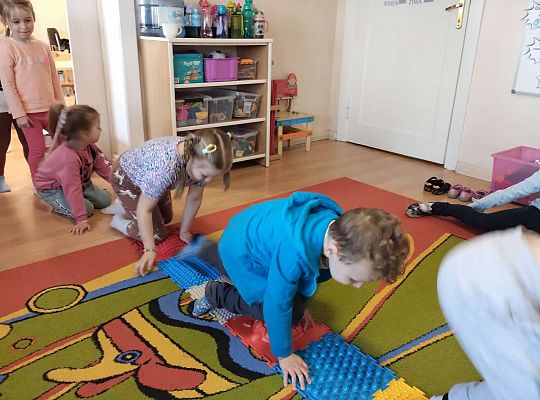 Dzieci idą po ścieżce sensorycznej