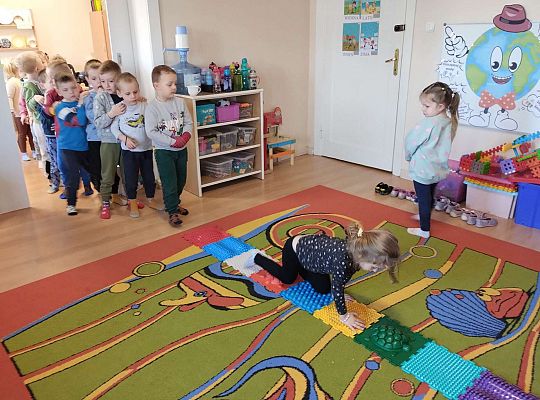 Dzieci idą po ścieżce sensorycznej