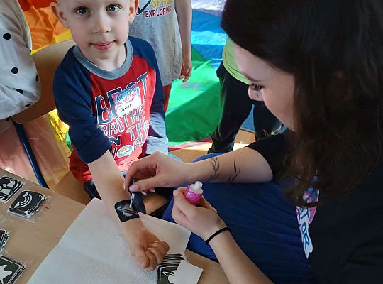 Pani maluje chłopcu tatuaż