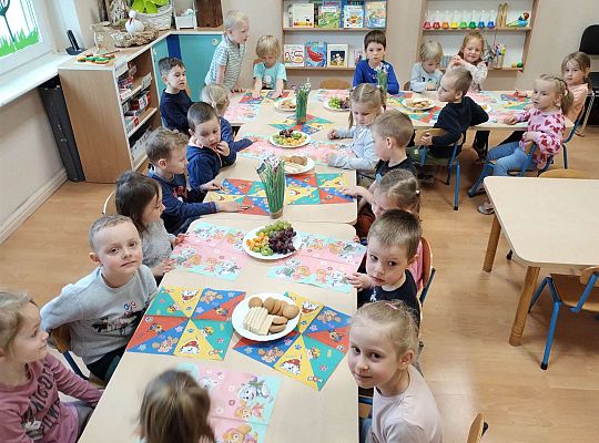 Dzieci jedzą owoce i ciastka