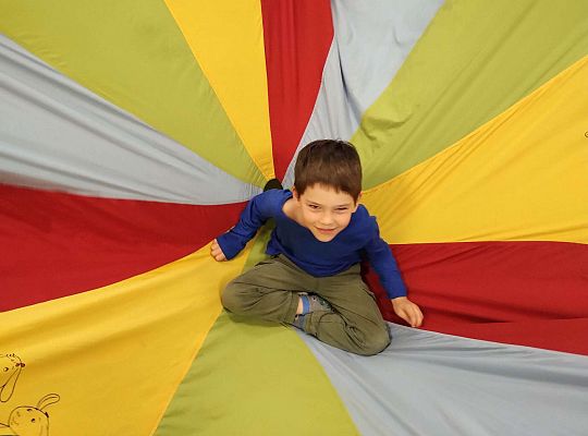 Chłopiec siedzi na środku chusty animacyjnej