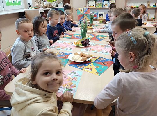 Dzieci jedzą owoce i ciastka