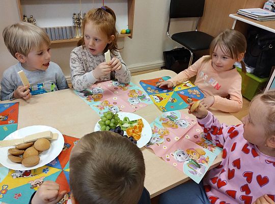 Dzieci jedzą owoce i ciastka