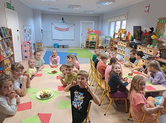 Dzieci siedzą przy urodzinowym stole