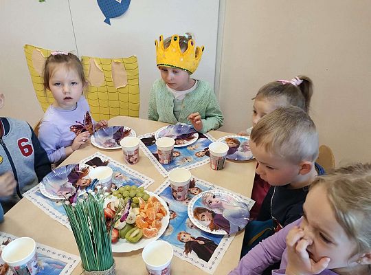 Dzieci siedzą przy urodzinowym stole