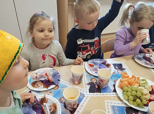 Dzieci siedzą przy urodzinowym stole