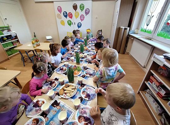 Dzieci siedzą przy urodzinowym stole