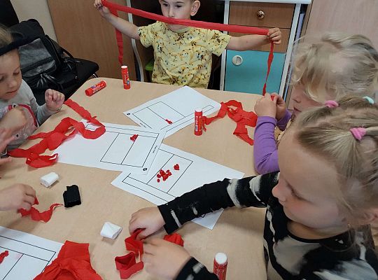 Dzieci wyklejają flagę kulkami z bibuły