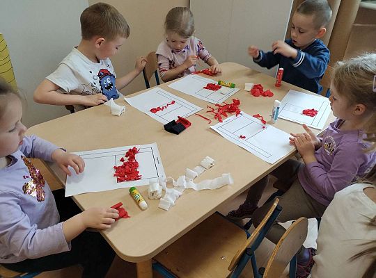 Dzieci wyklejają flagę kulkami z bibuły