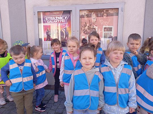 Dzieci stoją ustawione przed kinem