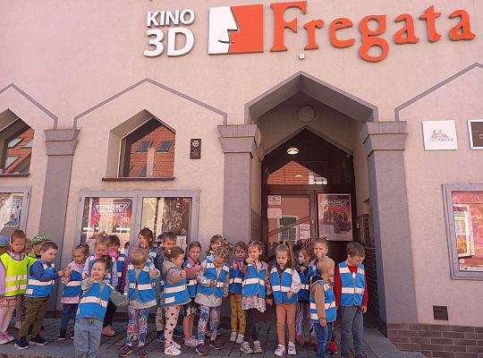 Dzieci stoją ustawione przed kinem