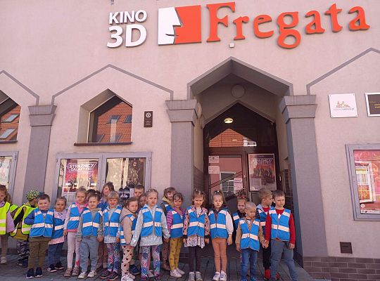 Dzieci stoją ustawione przed kinem