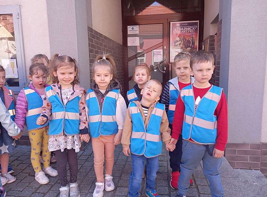 Dzieci stoją ustawione przed kinem