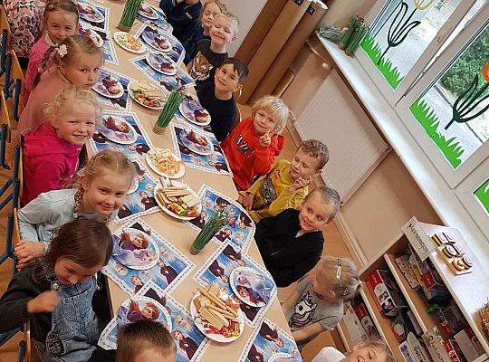 Dzieci siedzą przy stole urodzinowym