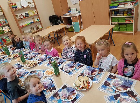 Dzieci siedzą przy stole urodzinowym