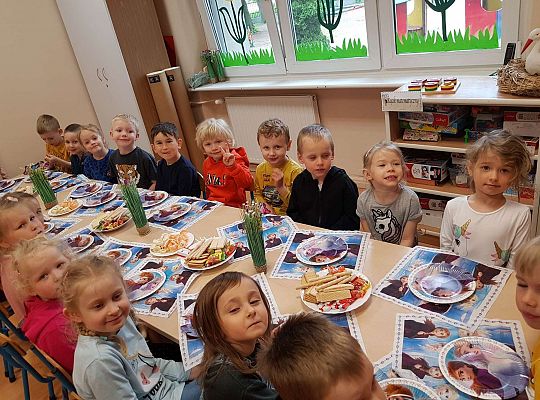 Dzieci siedzą przy stole urodzinowym