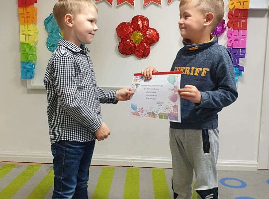 Chłopiec wręcza album solenizantowi