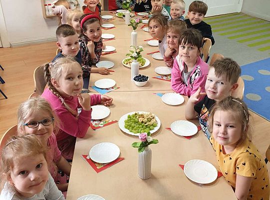 Grupa dzieci z solenizantem przy urodzinowym stole