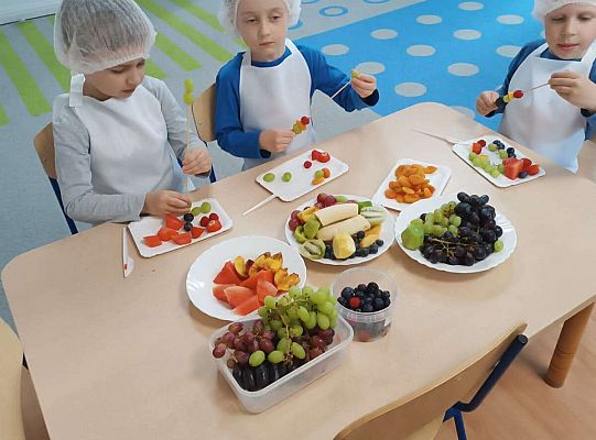 Dzieci robią owocowe szaszłyki