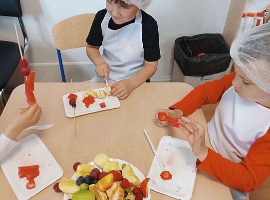 Dzieci robią owocowe szaszłyki