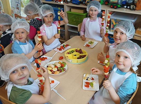 Dzieci robią owocowe szaszłyki