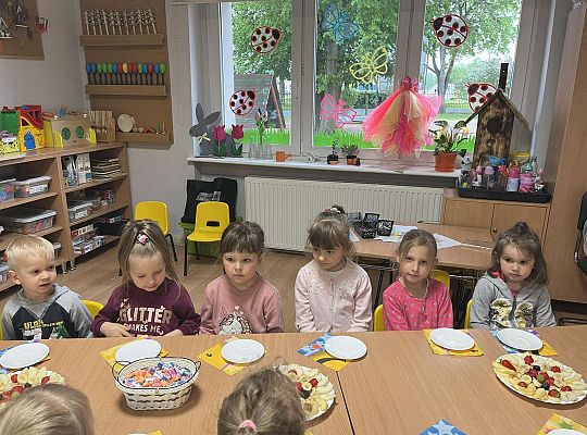 Dzieci siedzą przy urodzinowym stole