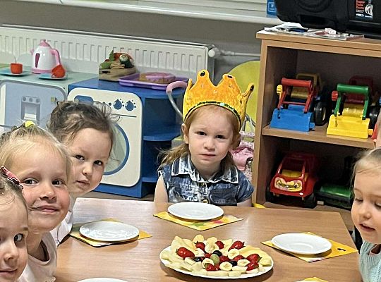 Dzieci siedzą przy urodzinowym stole