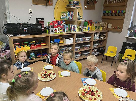 Dzieci siedzą przy urodzinowym stole