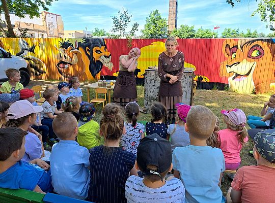 Dzieci słuchają opowieści o wiejskiej zagrodzie