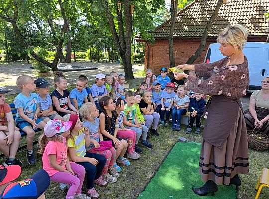 Dzieci słuchają opowieści o wiejskiej zagrodzie