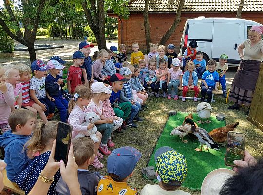 Dzieci siedzą na ławkach