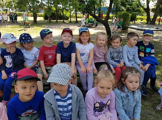 Dzieci siedzą na ławkach