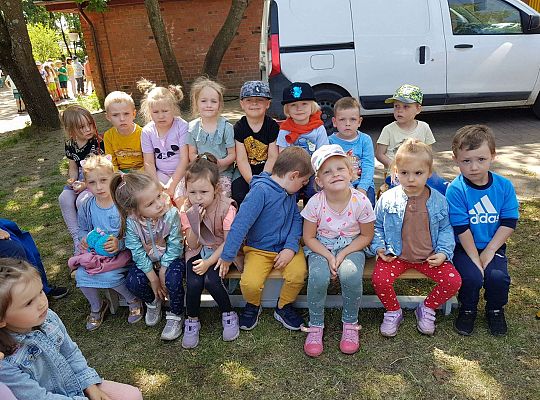 Dzieci siedzą na ławkach