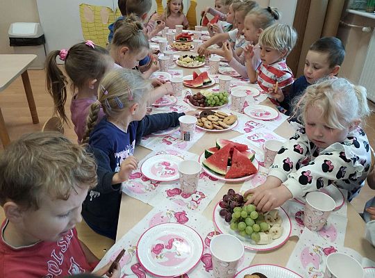 Dzieci jedzą owoce i ciasteczka