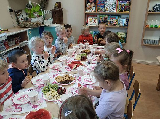 Dzieci jedzą owoce i ciasteczka