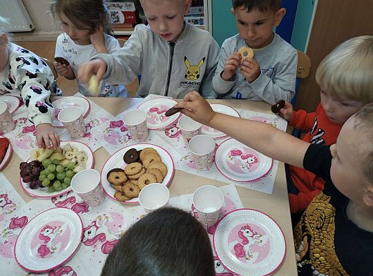 Dzieci jedzą owoce i ciasteczka