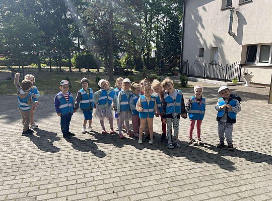 Dzieci stoją przy budynku Przedszkola