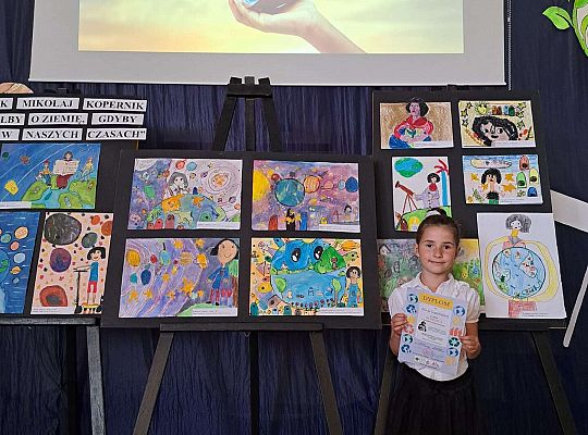 Dziewczynka na tle prac konkursowych