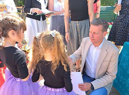 Dziewczynki odbierają dyplom za udział w konkursie