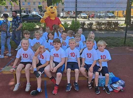 Grupa dzieci z Misiem Puchatkiem