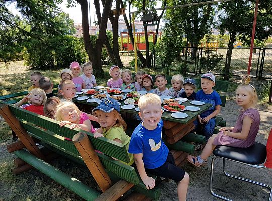 Dzieci siedzą przy urodzinowym stole