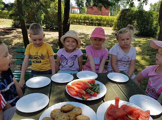 Dzieci siedzą przy urodzinowym stole