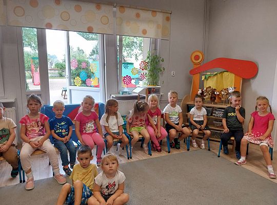 Grupa dzieci siedzi na krzesełkach