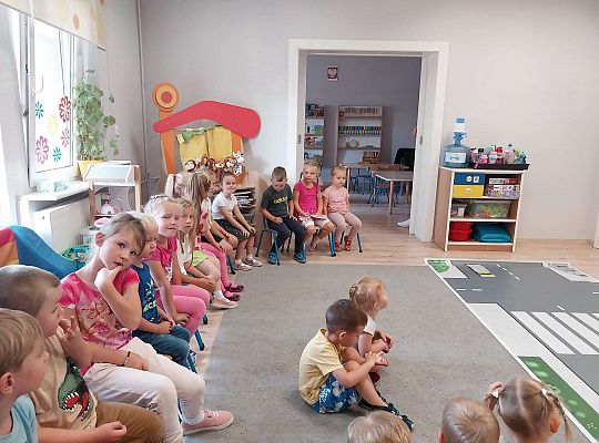 Grupa dzieci siedzi na krzesełkach