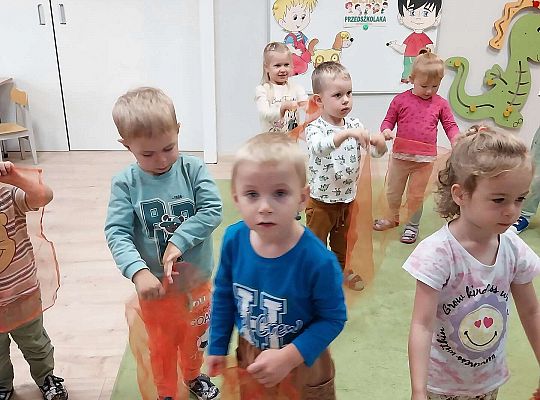 Dzieci tańczą z kolorowymi chusteczkami